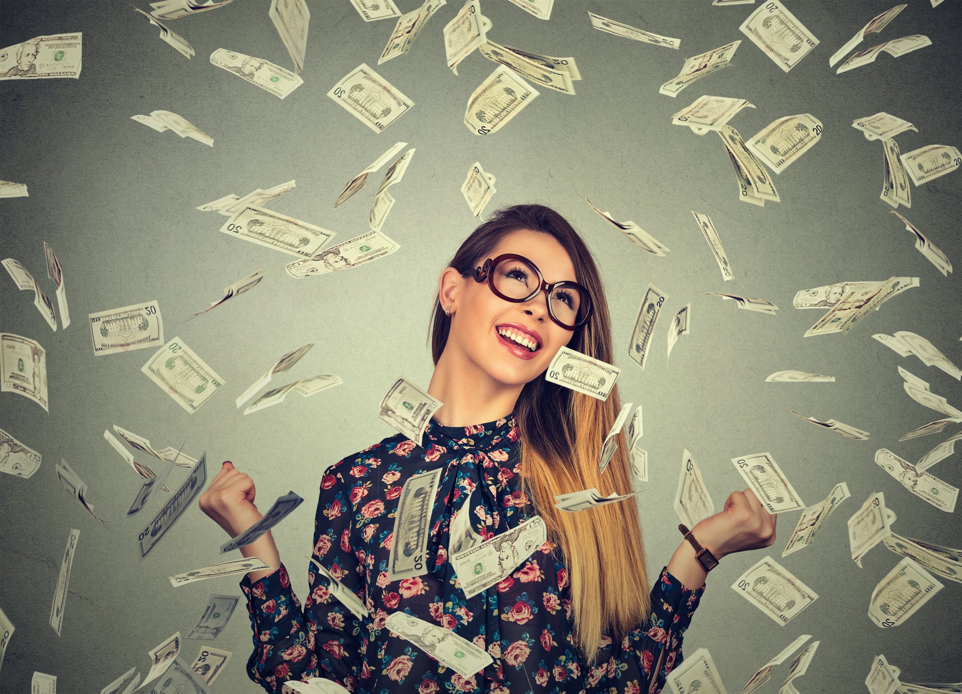 woman pumping fists celebrates success under money rain